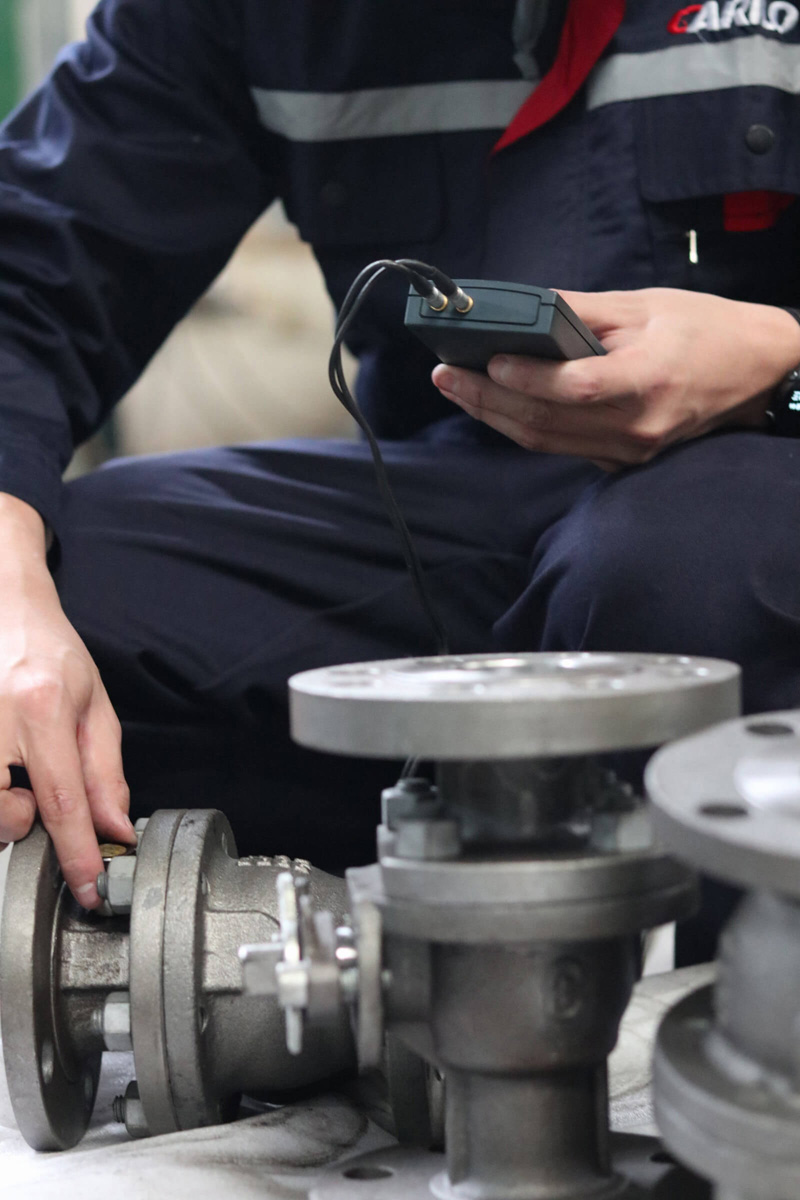 CARILO technician inspecting valve components during quality control